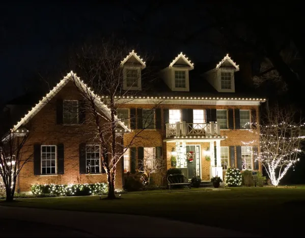 Brick colonial with warm white roofline and wrapped front trees